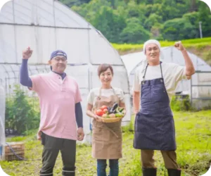 新鮮な農作物を手に持った生産者の人々の様子